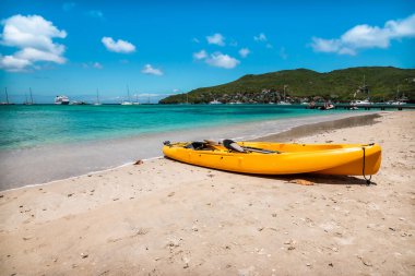 Bequia, St Vincent ve Grenadines 'in beyaz kumsalındaki sarı kano..