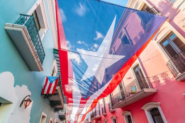 Large flag of Puerto Rico above the street in the city center of San Juan. clipart