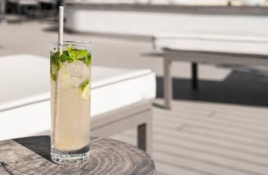 Lüks bir güverte sandalyesinin yanındaki tahta masada kağıt kamışla bakire Mojito. Yaz tatili içeceği.