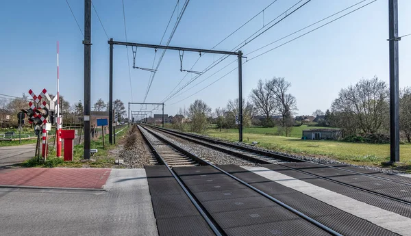 Railroad crossing in the countryside in Belgium. Railway and transportation concept.
