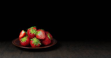 Belçika 'dan gelen taze kırmızı sulu çileklerle kaplı kahverengi bir tabak..