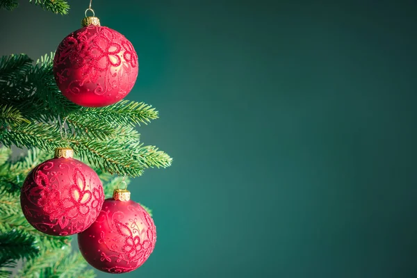 Kırmızı topları olan koyu yeşil Noel arkaplanı .