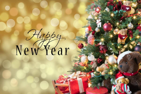 Mutlu yıllar mesajı: bulanık ve pırıl pırıl arka plan. Hediyeler ve oyuncak ayılarla sihirli Noel ağacı..