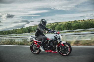 Split, Hırvatistan Haziran 2020 Yamaha Fazer motosikletli sürücü, yandan görülen beyaz ve kırmızı Abarth sürümü otoyolda yüksek hızda gidiyor