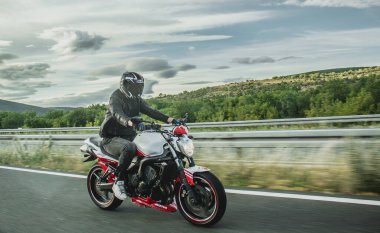 Split, Hırvatistan Haziran 2020 Yamaha Fazer motosikletli sürücü, yandan görülen beyaz ve kırmızı Abarth sürümü otoyolda yüksek hızda gidiyor