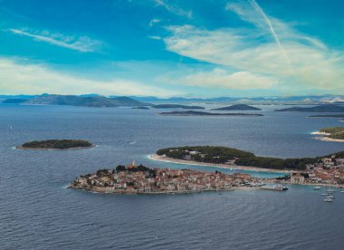 Primosten Yarımadası yakınlardaki bir tepeden görüldü. Mavi parlak bir gün, Adriyatik Denizi küçük eski kasabayı kuşatıyor.
