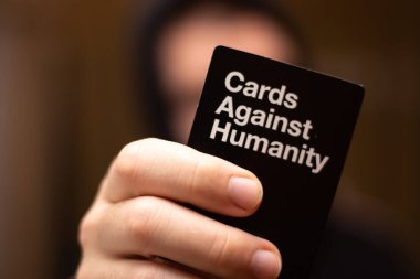 Split, Hırvatistan Nisan 2020 'de arka planda, yetişkinler için dünya çapında popüler bir parti oyunu olan insanlığa karşı kara kart tutan bulanık bir adam görülüyor.