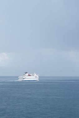 Split 'ten adalara giden büyük beyaz Hırvat feribotu. Yağmurlu bir fırtınada, denizde yapayalnız. Kara bulutlar uzanıyor.