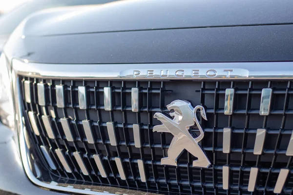 Yeni bir cipin önünde Peugeot logosu. Yeniden dizayn edilmiş ön ızgara solmuş gümüş renkleri.