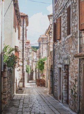Hvar adasındaki Starigrad kasabasındaki eski sokakları daraltın. Eski Yunan tarzı taş evler ve içinden geçen dar asfalt bir patika.