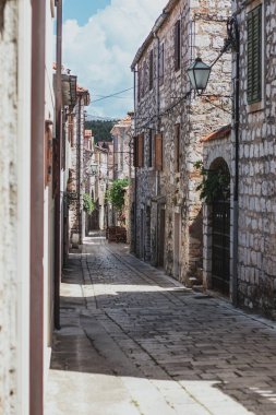 Hvar adasındaki Starigrad kasabasındaki eski sokakları daraltın. Eski Yunan tarzı taş evler ve içinden geçen dar asfalt bir patika.