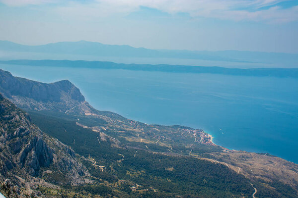 Panoramic view from the newly built Skywalk on Biokovo mountain in Croatia. View of the Adriatic sea, Podgora city. High mountains descending to sea level