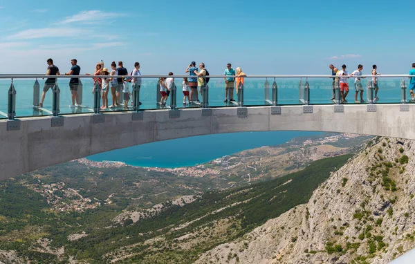 Biokovo dağında yeni inşa edilen gökyüzünde yürüyen turistler. Girişten, kasabalardan ve denizden geniş görüş alanı var.