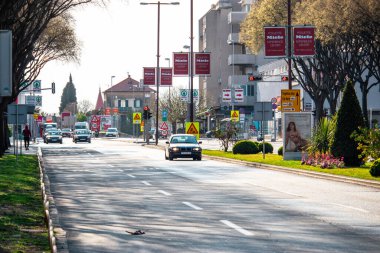 Hırvatistan 'ın Split kentinde üç şerit sokak. Geçen arabalar, odak noktasında BMW 1 serisi. Yoldaki kuş, direklerdeki reklamlar