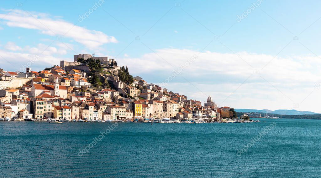 Old town of Sibenik, Croatia seen from a distant beach. Mediterranean typical traditional seascape view