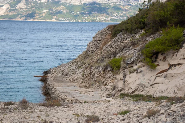 Hidden cove beach on the island of Brac, Croatia. Rocky shore with forest trees surrounding the small paradise. Area in front of the hidden bunker belonging to Yugoslavian leader Tito