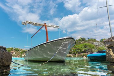 Brac Adası 'ndaki küçük Bobovisca limanına yanaşmış eski bir geminin güzel manzarası. Suyu ve tekneyi yansıtan ışıklar, kristal berraklığında Adriyatik Denizi ve ılık yaz günü