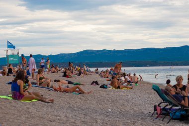 Bol Hırvatistan, Ağustos 2020 Covid küresel salgın sırasında turist ve gezginlerle dolu ünlü Zlatni Rat plajı sıcak bir yaz gününün tadını çıkarıyor