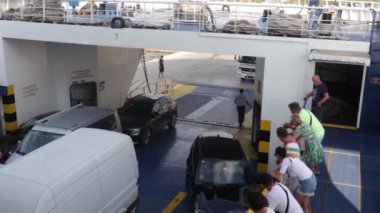 Supetar Hırvatistan Ağustos 2020 Araba feribotuna binen arabaların görüntüsü. İnsanlar dikilip izlerken son kamyon rampaya giriyor.