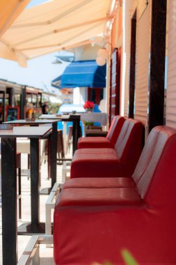 Biyogradda Adriyatik Denizi 'ndeki küçük bir kafede iki çift kırmızı deri sandalye. Yaz mevsiminin sonunda boş.