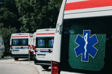 Coronavirus salgınının ortasında Hırvatistan 'ın Split kentinde birden fazla beyaz ambulans minibüsü park etti. Kapı pencerelerinde küresel sağlık sembolü