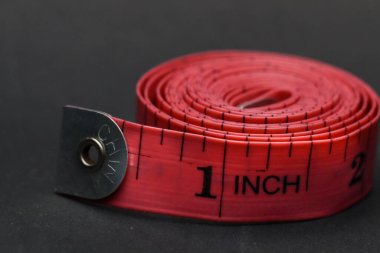 Siyah arkaplanda inç cinsinden kumaş için metre