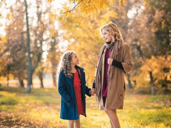 一个幸福的家庭的写照 一个年轻美丽的女人 和她可爱的女儿 年轻的女儿拥抱母亲在秋天室外 时尚家庭概念 — 图库照片