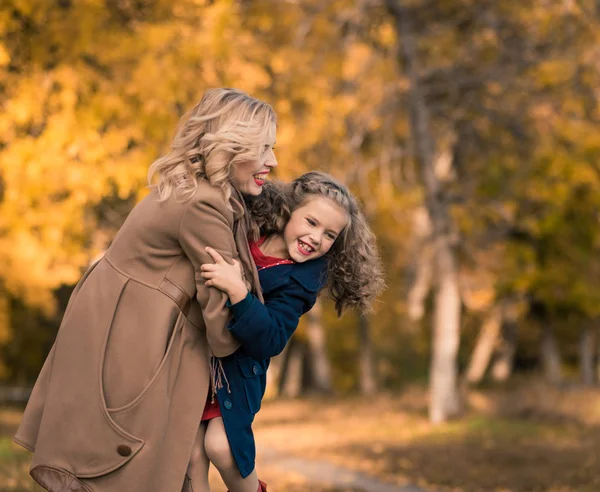 Beautiful mother and daughter in colorful autumn outdoors — Stock Photo, Image