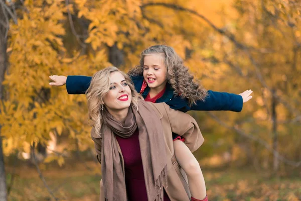 Schöne Mutter und Tochter im bunten Herbst im Freien — Stockfoto