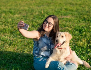 genç kadın ve bir selfie bir parkta alarak onun dostu köpek