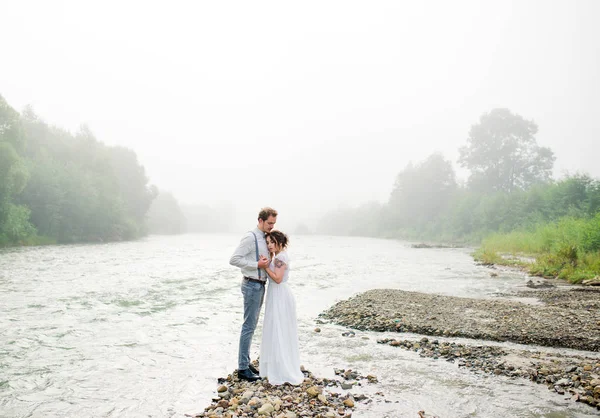 美しい花嫁と花婿 ただそもそも 結婚式のカップル クローズ アップ 幸せな新郎新婦の結婚式のハグに 山の美しい自然 霧で新郎新婦 — ストック写真