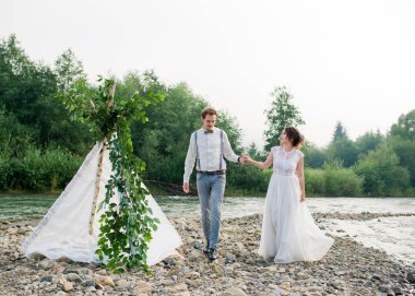 Güzel gelin ve damat. Sadece evlenmiş. Düğün çifti. Yakın çekim. Mutlu gelin ve damat onların düğün sarılma üzerinde. Gelin ve damat Dağları, güzel doğa, manzara, sis
