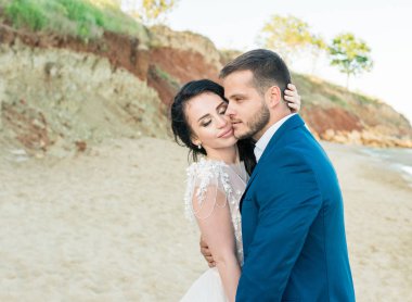 Gelin ve damat düğün töreninde günbatımı tarafından deniz kenarında