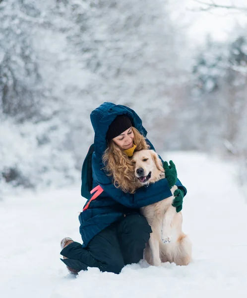 Young woman plaing with golden retriever on winter walk. — Stock Photo, Image