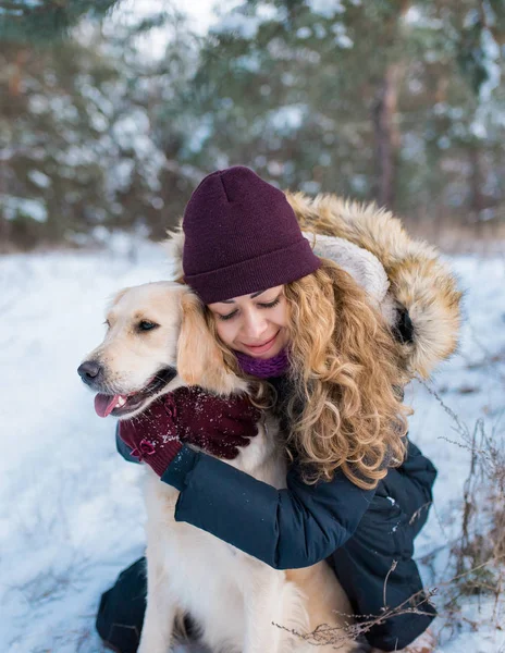 oung güzel kadın kucaklama golden retriever köpek karda