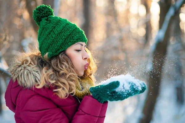 Muchacha joven atractiva en invierno al aire libre soplando nieve — Foto de Stock