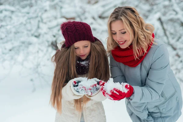 Mladá rodina si zábavu a sněhuláka v zasněženém parku — Stock fotografie