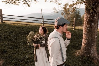 İki sevgili hill, öpücük ve kucaklama, bir aşk hikayesi üstünde yürümek. Güzel çift düğün gününde dağlar tepede poz