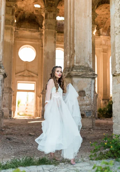 Ritratto di giovane sposa in boudoir di pizzo bianco con capelli ondulati — Foto Stock