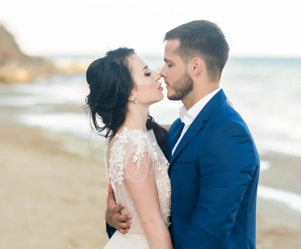 Casamento casal, noivo e noiva em vestido de noiva perto do mar à beira-mar — Fotografia de Stock