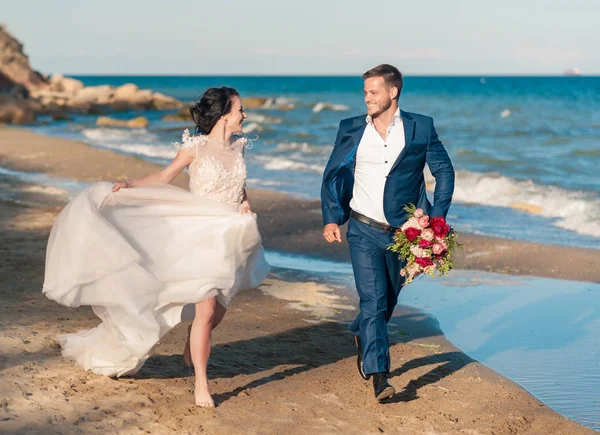 Casamento casal, noivo e noiva em vestido de noiva perto do mar à beira-mar — Fotografia de Stock