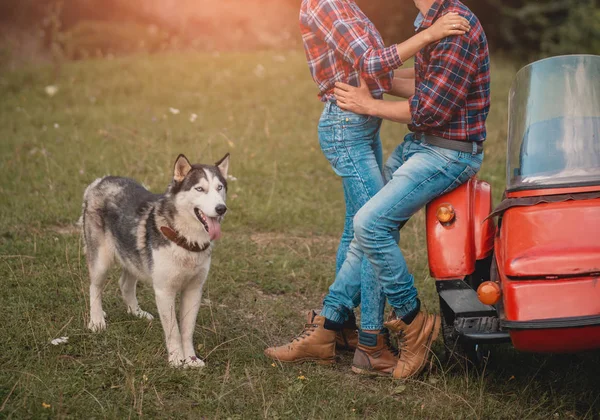 Νεαρό ζευγάρι ευτυχισμένο plaing με σκυλιά husky σε εξωτερικούς χώρους — Φωτογραφία Αρχείου