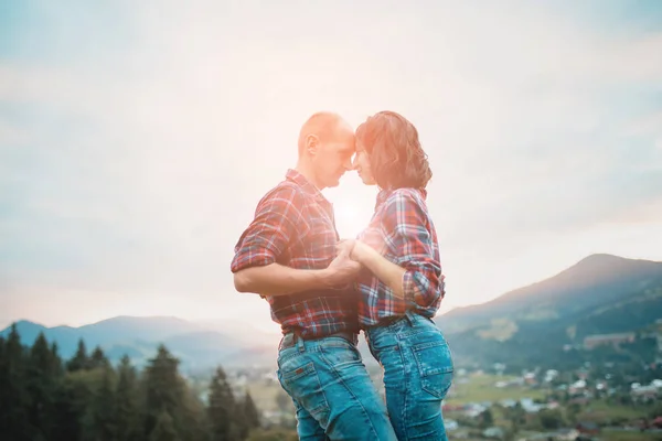 Pareja disfrutando de la hermosa puesta de sol sentados juntos en la montaña con una gran vista —  Fotos de Stock