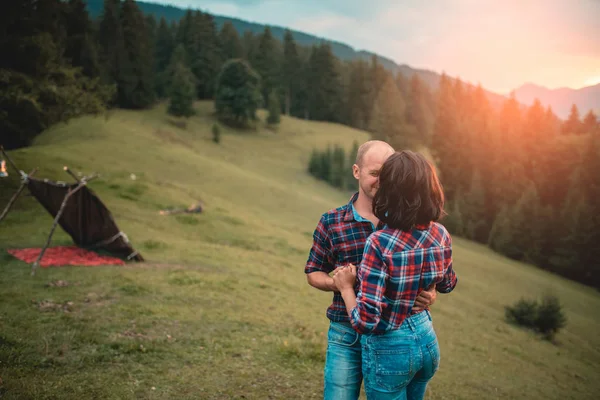 Couple enjoying beautiful sunset sitting together on the mountain with great view — Stock Photo, Image