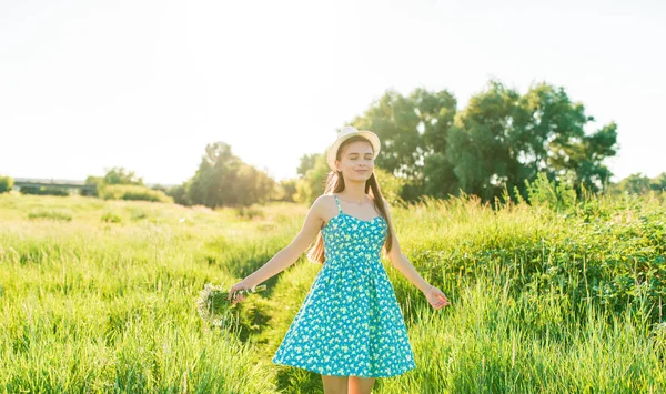 Jong meisje met bos van kamille in een veld met hoog gras — Stockfoto