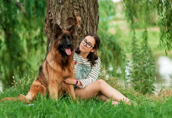 Donna abbraccio il suo cane pastore tedesco nel parco estivo — Foto Stock