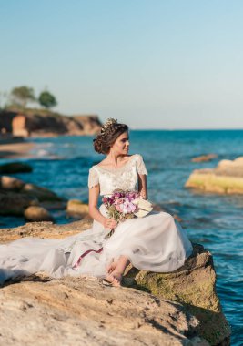 Sahilde poz lüks elbiseli romantik güzel gelin.