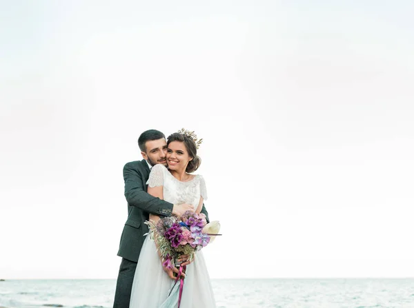 Couple de mariage, marié et mariée en robe de mariée près de la mer à la mer — Photo