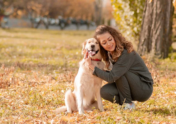 Красивая улыбающаяся женщина с милой золотистой собакой ретривера — стоковое фото