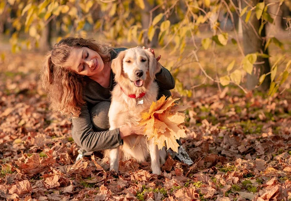 Jeune belle femme étreignant chien golden retriever — Photo